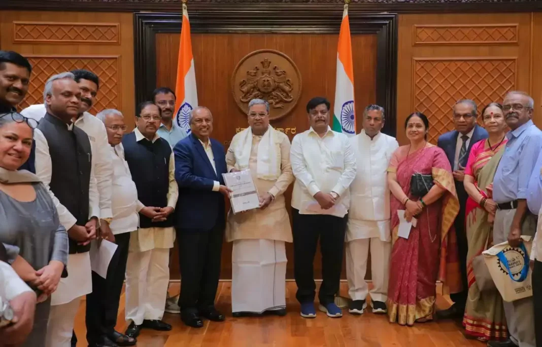 कर्नाटक मुख्यमंत्री सिद्धारमैया को नागमोहन दास आयोग की रिपोर्ट सौंपते हुए