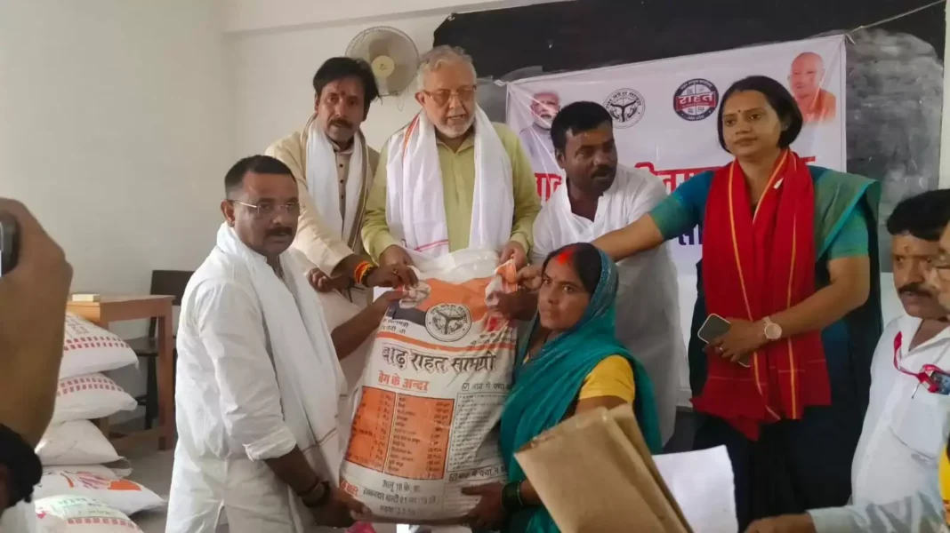 वाराणसी में बाढ़ पीड़ितों को राहत सामग्री देते उत्तर प्रदेश के प्रभारी मंत्री सुरेश खन्ना