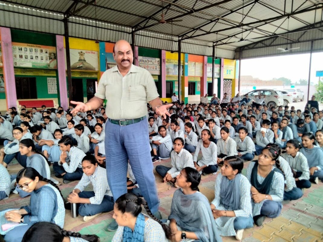 बिठमड़ा में बाल परामर्श केंद्र उद्घाटन कार्यक्रम में किशोरियों को संबोधित करते अधिकारी