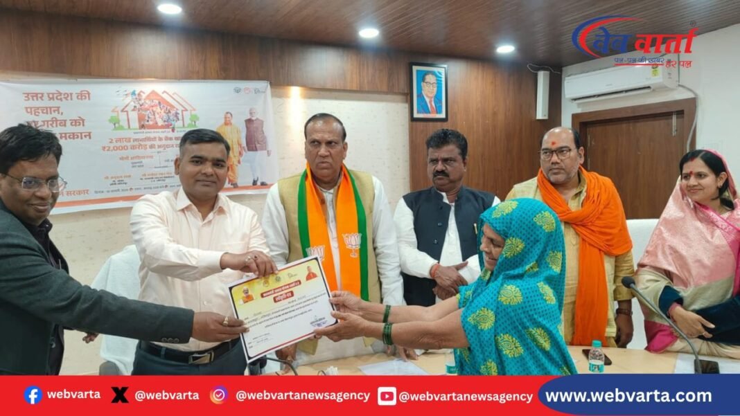 lalitpur-pm-awas-yojana-urban-first-installment-beneficiaries-2026 ललितपुर में पीएम आवास योजना शहरी 2.0 के अंतर्गत लाभार्थियों को पहली किश्त का प्रमाणपत्र देते अधिकारी।