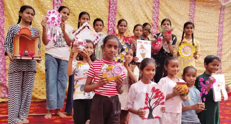 ग्रामीण विरासत महोत्सव में बच्चों द्वारा बनाई गई हस्तशिल्प कलाकृतियों की प्रदर्शनी देखते लोग